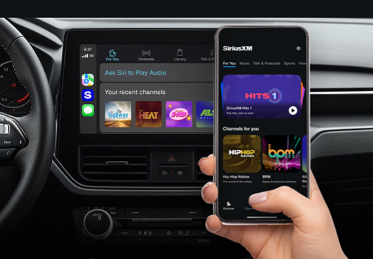 Image of car interior showing in-car entertainment system and a phone showing the SiriusXM app